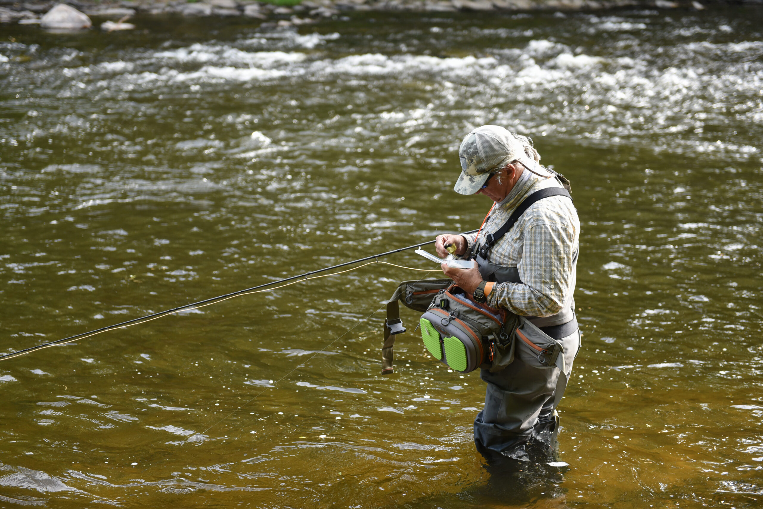 Tim Flagler changes his fly while fishing for bass