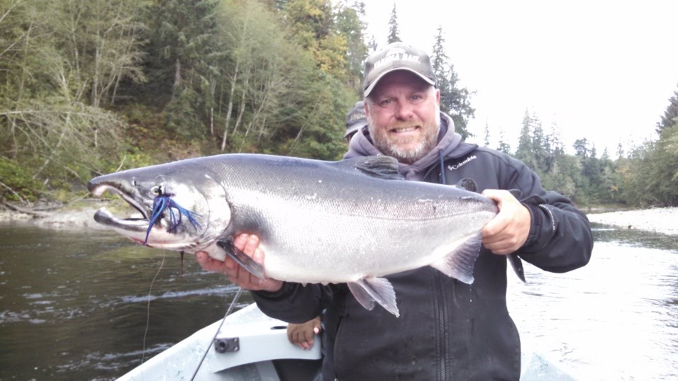 Bob Kratzer is showing off a coho salmon he caught while twitching
